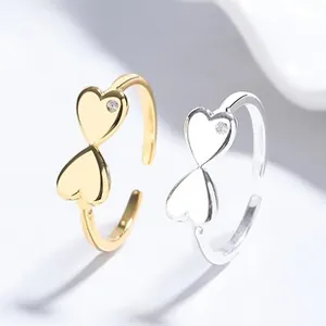 Close-up of interlocking heart-shaped rings in gold and silver finish with small zircon