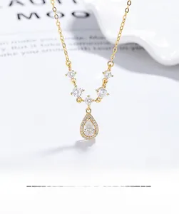 Detailed macro view of the gold teardrop zircon pendant and fine silver chain detail