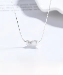 Macro shot of 925 sterling silver pea-shaped pendant with a brushed metal finish