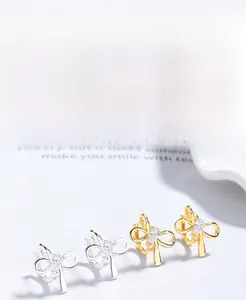 Détail de boucles d'oreilles nœud en argent S925 avec zircone en forme de cœur, or et argent