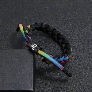 Close-up of Leo zodiac braided bracelet with rainbow lace and black metal cylinder buckle