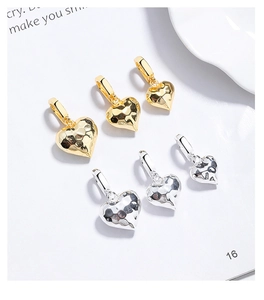 Detailed view of six 925 silver heart pendants in gold and silver with hammered texture