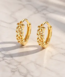 Macro-opname van vergulde S925 sterling zilveren holle bloem oorbellen voor dames