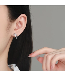 Gros plan de boucles d'oreilles nœud en argent S925 avec zircon sur le modèle
