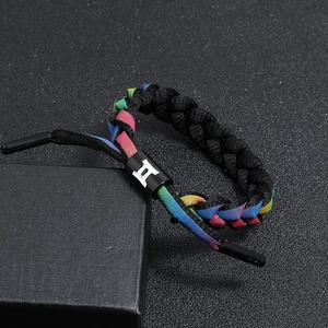 Detail of woven rainbow shoelace bracelet with black Gemini zodiac symbol slide buckle
