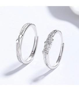 Macro shot of silver adjustable couple rings featuring flower detail and wavy brushed texture