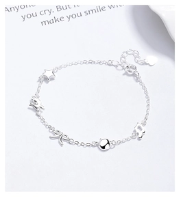Détail du bracelet en argent 925 avec breloques étoile, nœud et note de musique
