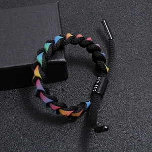 Detail of rainbow braided bracelet with black metal clasp showing engraved date range