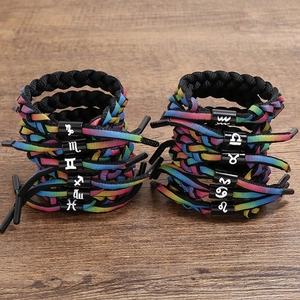 Rainbow braided shoelace bracelet with twelve zodiac signs on wooden background
