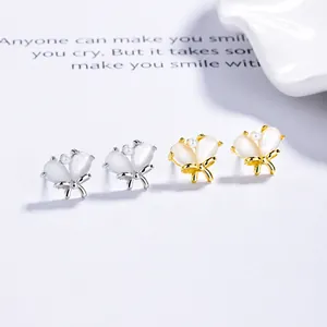 Detailed view of cat eye stone butterfly stud earrings with pearl accents in gold and silver