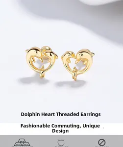 Macro shot of 925 sterling silver dolphin and heart-shaped screw-back stud earrings