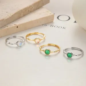 Detail of four bamboo-style adjustable rings with emerald green and opal gemstones