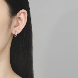 Boucles d'oreilles étoiles en argent 925 avec zircons scintillants sur fond gris clair