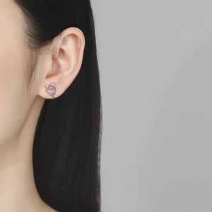 Pink cat-shaped 925 silver clip earrings with opal stone on a model's ear