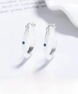 Macro shot of 925 sterling silver hoop earrings with brushed finish and blue gemstones