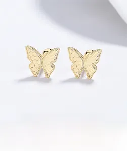 Detail view of golden butterfly stud earrings with ice texture and screw back closures