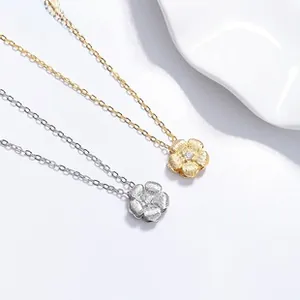 Detail of 925 silver flower pendants in gold and silver finish with zircon center