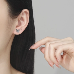 925 silver butterfly stud earring with black zircon inlay on a model's ear