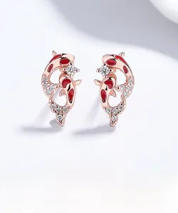 Macro shot of 925 silver koi earrings with red enamel and sparkling zircon details