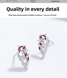 Macro shot of S925 sterling silver koi fish earrings with red enamel and zircon stones
