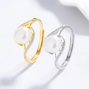 Detail of silver fish tail ring with freshwater pearl and sparkling zircon stones