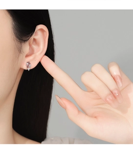 Detail of S925 silver koi stud earring with red agate and white zircon on ear