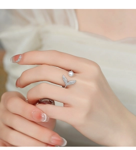 Close-up of 925 sterling silver fishtail ring with pearl and sparkling zircon stones