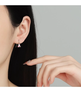 Close-up of a pink tulip enamel earring on model with elegant silver hook detail