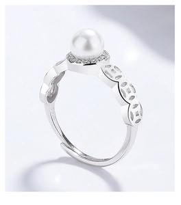 Détail de bague en argent S925 avec perle, accents de zircon et anneau à motif de pièces