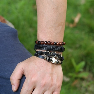 Men's retro braided leather bracelet set with red tiger eye beads on outdoor background