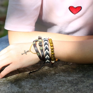 Three-piece leather beaded bracelet set featuring a cross charm and woven fabric texture