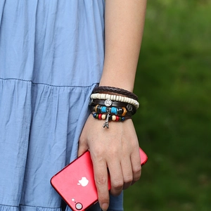 Bohemian multilayer leather bracelet with Eiffel Tower and peace sign charms on wrist