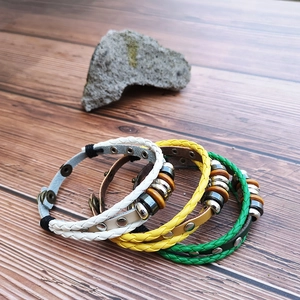 Detailed view of bohemian braided leather bracelets set with wood beads and metal rings