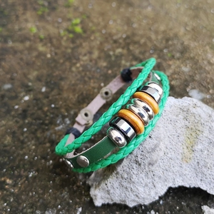 Detail of multi-layer green braided leather bracelet with beads on natural stone