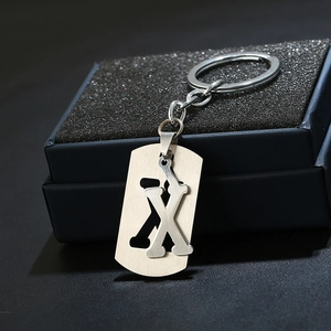 Detailed macro view of silver metal keychain with letter X pendant in a gift box