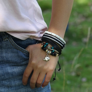Men's multilayer leather beaded bracelet set with silver fish charm worn on wrist