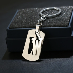Detail of brushed stainless steel letter W keychain in a gift box with sponge lining