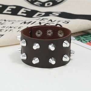 Nahaufnahme eines braunen Punk-Lederarmbands mit silbernen Nieten und Druckknöpfen