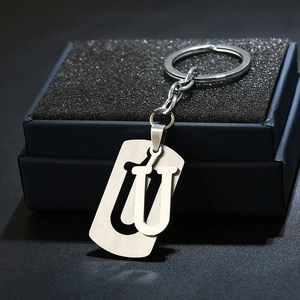 Detail of silver stainless steel letter U keychain with a brushed metal texture on a box
