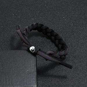 Détail des embouts réfléchissants holographiques sur bracelet tressé noir Yin Yang
