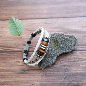 Detail of white multi-layer woven leather bracelet with metal beads and snap button closure