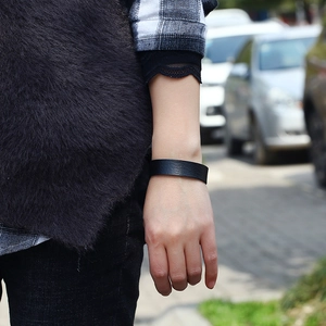 Minimalist black leather cuff bracelet with matte texture shown on a woman's wrist
