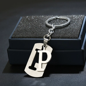 Macro shot of stainless steel letter P keychain with hollow rectangle pendant on gift box