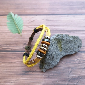 Bohemian braided leather bracelet with yellow cord, wooden beads, and bronze snap button