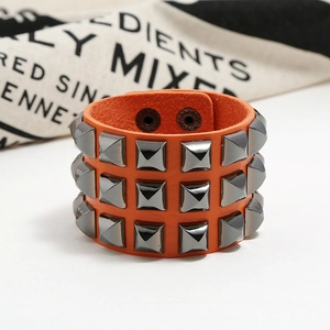Detail view of wide orange leather punk bracelet with triple row metal studs and snaps