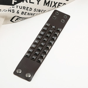 Punk style wide leather bracelet featuring three rows of pyramid metal studs and snap buttons