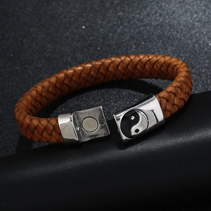 Macro detail of brown braided leather bracelet with Yin Yang magnetic metal clasp