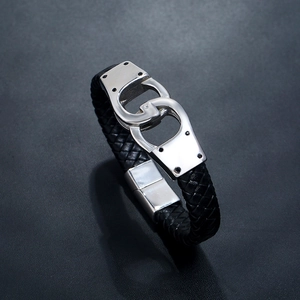 Detail of black braided leather bracelet featuring a silver double-ring buckle clasp
