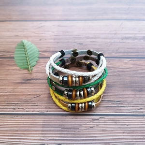 Handmade woven leather beaded bracelets in white, green, and yellow bohemian style