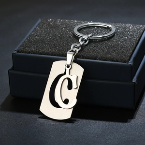 Close-up of silver stainless steel keychain featuring a hollow shield letter C design